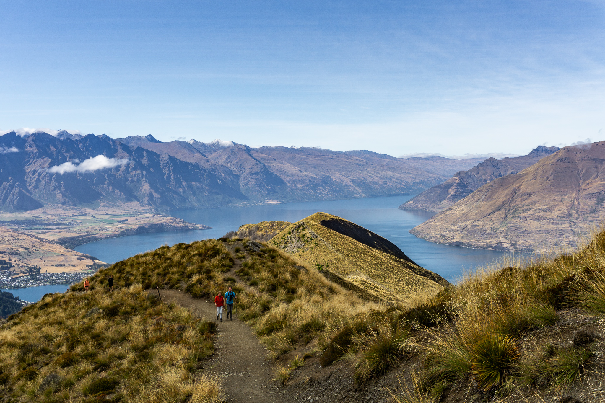 Photo of hikers walking up the track with Lake Wakatipu in the background