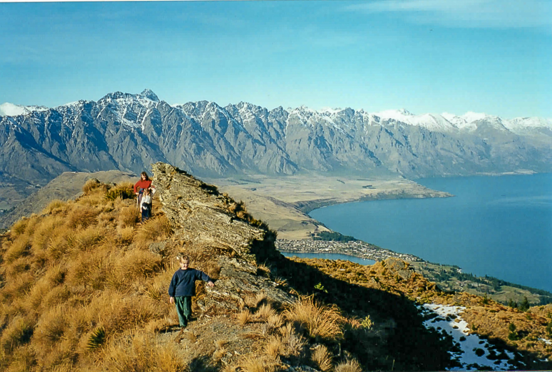 Old photo of family walking along the Ben Lomond track with the Remarkables and Lake Wakatipu in the background